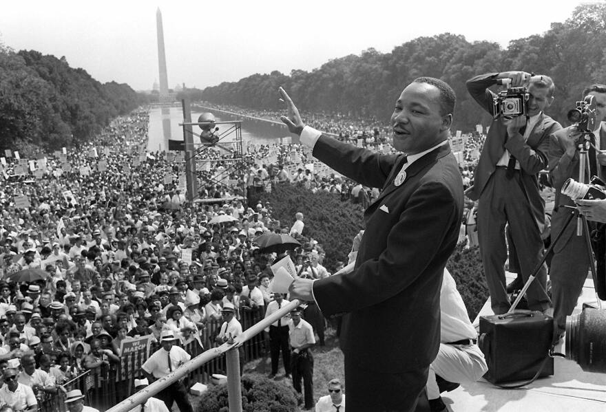 File: Martin Luther KIng (C) waves to supporters from the steps of the Lincoln Memorial August 28, 1963.