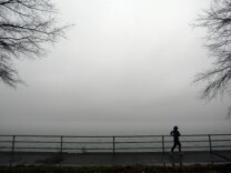 A jogger disappears into the fog along the Potomac River.