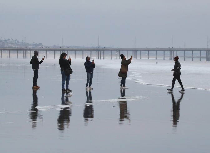 VENICE BEACH, CALIFORNIA - DECEMBER 13: Four people take cell phone images of one person near the Venice Beach Pier on December 13, 2019 at Venice Beach, California. (Photo by Bruce Bennett/Getty Images)
