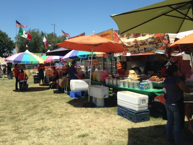 Food vendors set up in South Gate Park on July 4, 2016 as U.S. and Mexican flags wave in the background.