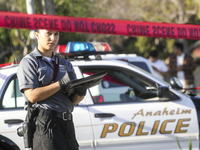 A police officer investigates the scene near Pearson Park in Anaheim, California,  February 27, 2016, after three counter-protesters were stabbed while clashing with Ku Klux Klan members staging a rally. Thirteen people were arrested. / AFP / RINGO CHIU        (Photo credit should read RINGO CHIU/AFP/Getty Images)