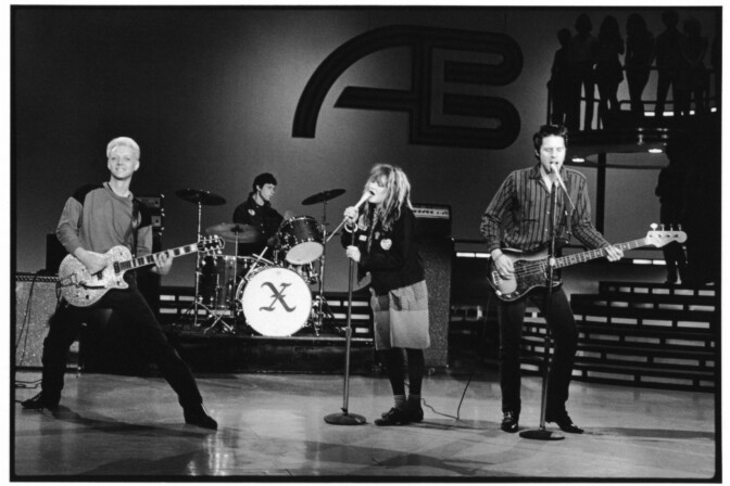 Black and white photo of four musicians playing on stage at American Bandstand.