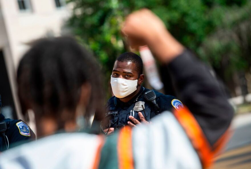 A protester speaks with a police officer in 'Black Lives Matter' plaza near the White House in Washington, DC on June 24, 2020. (Photo by ANDREW CABALLERO-REYNOLDS / AFP) (Photo by ANDREW CABALLERO-REYNOLDS/AFP via Getty Images)