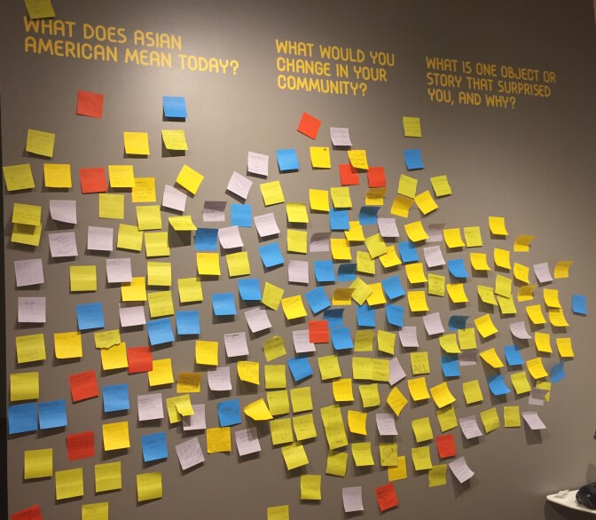 The gray wall at the exhibit asks three questions.