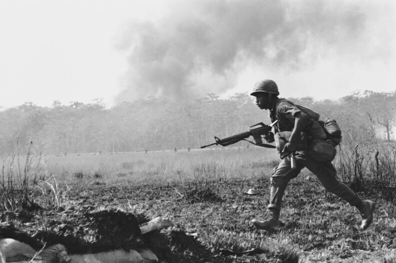 An infantry soldier runs across a burned-out clearing in Vietnam on Jan. 4, 1967.