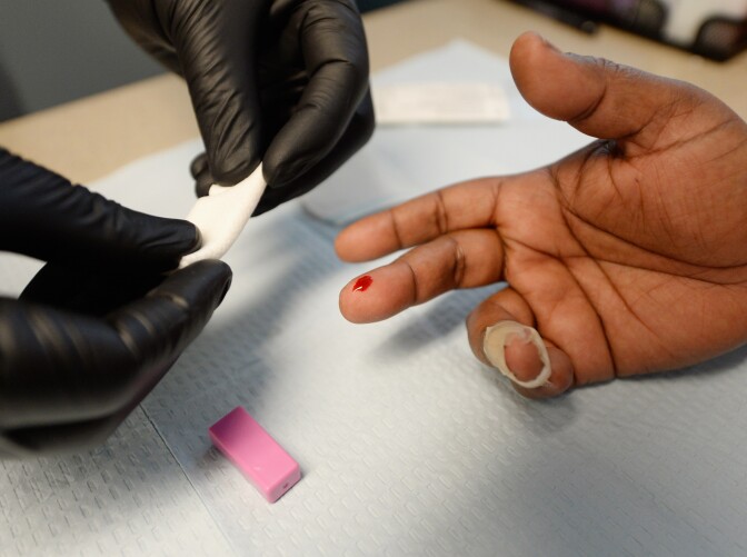 A woman gets an instant  HIV/AIDS test inside a moblile clinic of John Wesley Community Health Institute on June 5, 2013 in Los Angeles, California. 