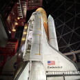 A space shuttle stands in it's launch position. A hatch on the shuttle is open. 