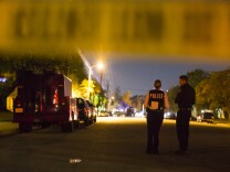 Redlands Police stand near Center Street and Pine Avenue on Wednesday night, Dec. 2, 2015 as authorities serve a search warrant following a mass shooting inside the the Inland Regional Center in San Bernardino on Wednesday, Dec. 2, 2015.