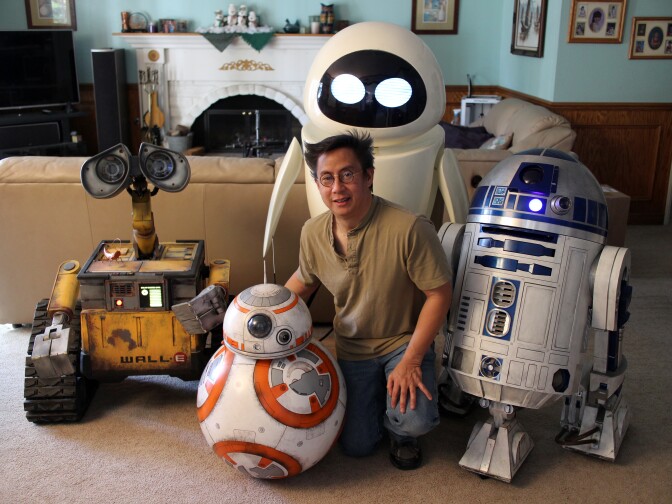 R2 builder Mike Senna poses with his creations in his home in Yorba Linda, Calif.