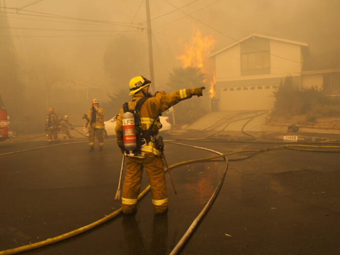 Los Angeles city firefighters try to contain a  the edge of the Creek Fire as it moves into a neighborhood in Lakeview Terrace on Dec. 5, 2017.