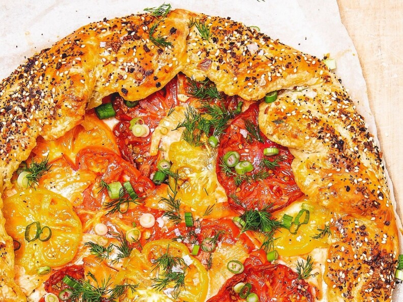 A galette has sliced tomato and chives