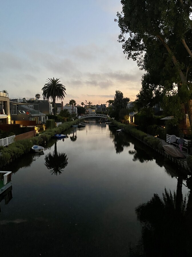 The Venice canal photographed at Sunset with houses on each side.