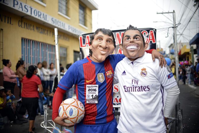 Revelers dressed as Argentinian football player Lionel Messi and Portuguese player Cristiano Ronaldo take part in the traditional "Convite de fieros" festival as part of All Saints Day celebrations in Villa Nueva, Guatemala on November 1, 2016.