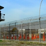 California Department of Corrections officer looks on as inmates at Chino State Prison exercise in the yard December 10, 2010 in Chino, California.