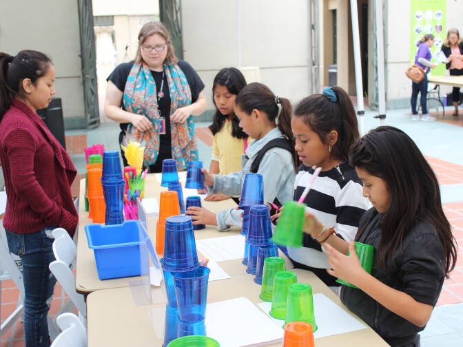 Children’s librarian Brooke Sheets (center) uses colored cups to teach algorithms and debugging to a group of girls at a computer science fair at L.A.'s downtown Central Library