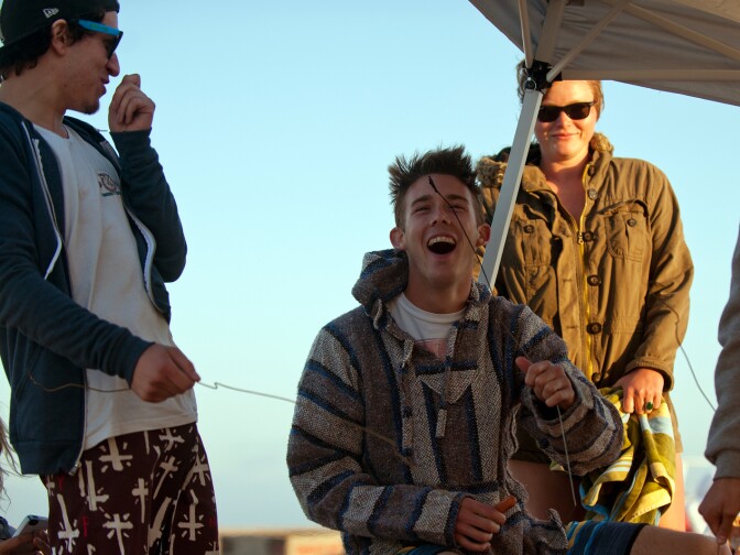 Thomas Ohanesian and Erik Fuog of Yorba Linda cook hot dogs at a fire pit on Huntington Beach.