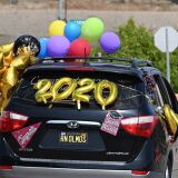 Graduating students from Mount San Antonio College receive their diplomas through their car window at a drive-thru commencement ceremony for the "Resilient Class" of 2020, which includes more than 650 students, June 18, 2020 in Walnut, California. - The college design the car-based ceremony to comply with Los Angeles County and California state COVID-19 gathering restrictions. (Photo by Robyn Beck / AFP) (Photo by ROBYN BECK/AFP via Getty Images)