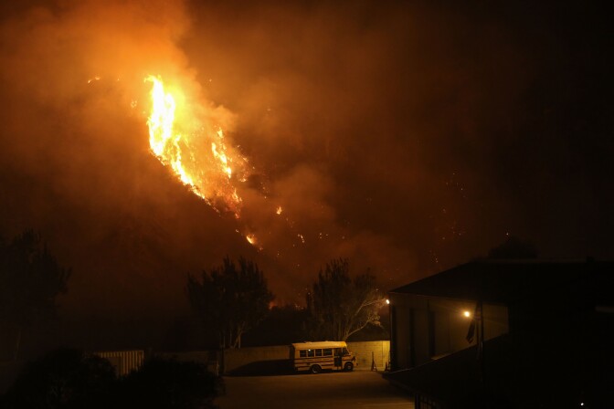 VENTURA, CA - DECEMBER 07:  The Thomas Fire burns near a school bus on December 7, 2017 in Ventura, California. The fire has destroyed 439 structures and burned 115,000 acres.  (Photo by Mario Tama/Getty Images)