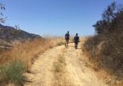 Miguel Ordeñana and A Martinez hike up to a wildlife camera in Griffith Park.