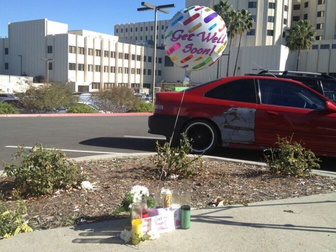 Flowers, candles and a balloon left outside of a Loma Linda hospital where passengers injured in a fatal tour bus crash are being treated on February 4, 2013.