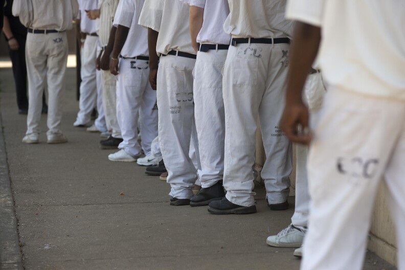 In this June 18, 2015 photo, prisoners stand in a crowded lunch line during a prison tour at Elmore Correctional Facility in Elmore, Ala. Alabama is trying to stave off federal intervention in its overcrowded  prison system with a reform package approved this spring that includes a bond issue for additional prison space and a new law making sweeping changes to sentencing and probation standards. (AP Photo/Brynn Anderson)