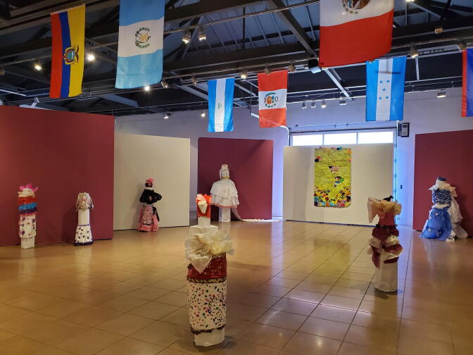 An image of an art exhibition of dresses made with paper and other art at MOLAA.
