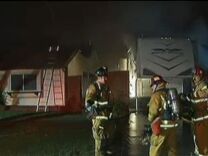 Firefighters work to extinguish flames near a home in Riverside County on February 28, 2013.