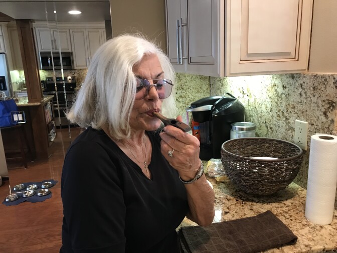 Linda Tisbo, a member of the Laguna Woods Medical Cannabis Collective, cleans out her pipe on April 11, 2018. The collective has more than 800 members. 