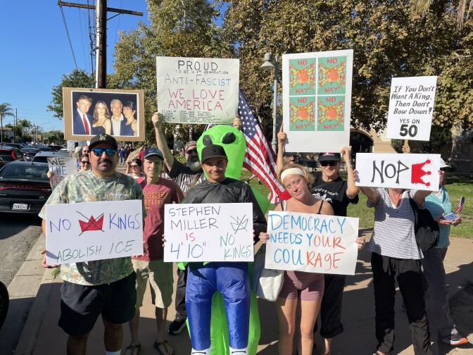 Protesters hold anti-Trump signs. 