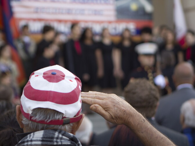 An attendee salutes the American flag during the presentation of the colors.
