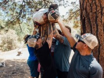 Jesus Guzmán (right) and fellow Higher Ground veterans participate in a team-building exercise during a hike in Big Bear, CA.