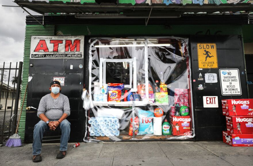 LOS ANGELES, CALIFORNIA - APRIL 10: Victor Torres wears a face mask in front of the store where he works, now protected by plastic due to the coronavirus pandemic, on April 10, 2020 in Los Angeles, California. Residents of Los Angeles and workers are required by law to wear masks or other face coverings at 'essential' businesses to protect against the spread of the coronavirus (COVID-19). (Photo by Mario Tama/Getty Images)