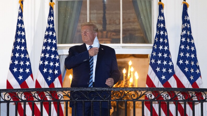 Trump removes his mask on a White House balcony