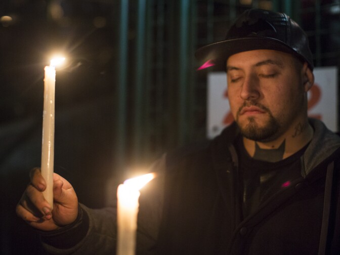 Attendees take part in a moment of silence as victims names are read aloud at the conclusion of a vigil at San Manuel Stadium in San Bernardino on Thursday night, Dec. 3, 2015 following a mass shooting that left 14 people dead and 21 injured on Wednesday at the Inland Regional Center.