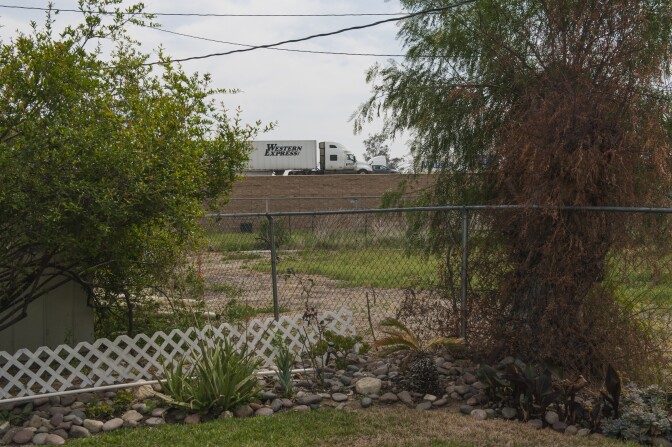 Trucks on the SR 60 Freeway are seen from Anna Gallegos' backyard in Mira Loma Village, California