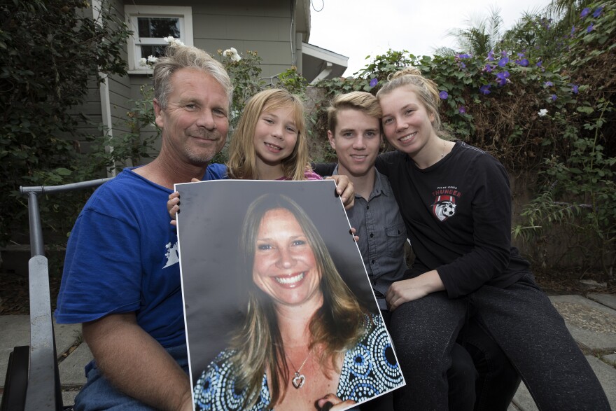 Husband Bob Patterson, right, and his children Robert, Amber and Brooke hold a photograph of Lisa Patterson in Lomita, Calif. on Oct. 30, 2017. Lisa Patterson was killed during the Oct. 1 attack in Las Vegas.