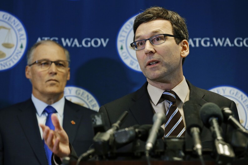 File: Washington Attorney General Bob Ferguson, right, talks to reporters as Gov. Jay Inslee, left, looks on, Monday, Jan. 30, 2017, in Seattle. Ferguson announced that he is suing President Donald Trump over an executive order that suspended immigration from seven countries with majority-Muslim populations and sparked nationwide protests.