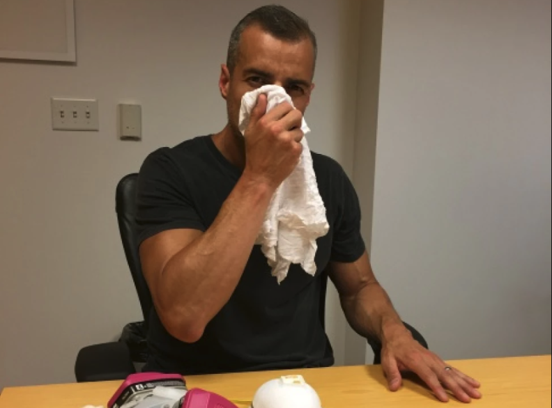 A man holds a handkerchief to his mouth