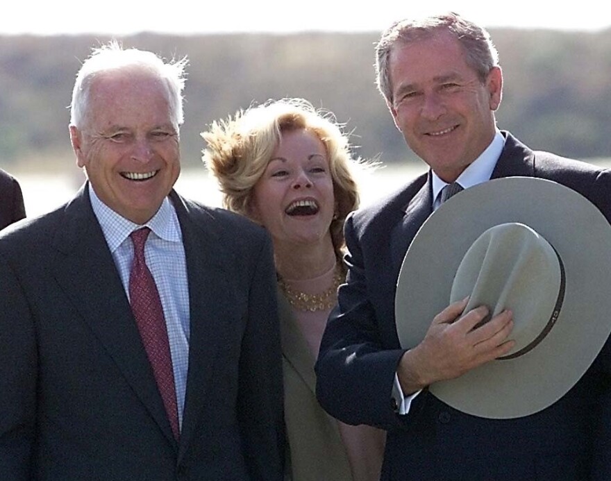 US President George W. Bush (R) receives a cowboy hat from Los Angeles Mayor Richard Riordan (L) and his wife Nancy Daly (C) after arriving at  Los Angeles International Airport  28 May 2001 in California. 