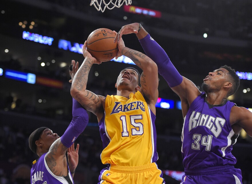 Los Angeles Lakers guard Jabari Brown shoots between Sacramento Kings guard Ben McLemore, left, and forward Jason Thompson during the first half of an NBA basketball game, Wednesday, April 15, 2015, in Los Angeles. (AP Photo/Mark J. Terrill)