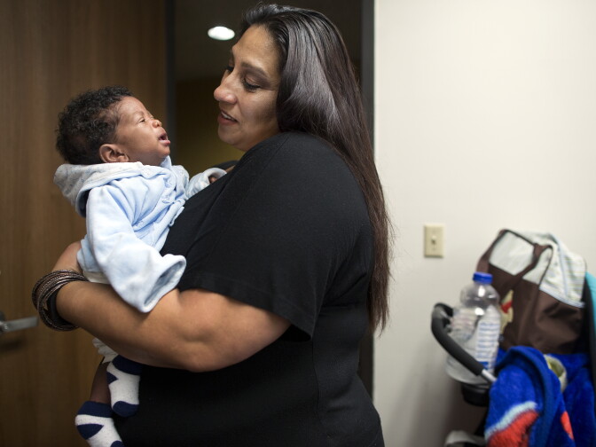 Health educator Cecie Trujillo holds 2-month-old Tray'von Lynn, son of class attendee Tamika Rosser. Inglewood-based Great Beginnings for Black Babies aims to reduce infant mortality  through support like this class.
