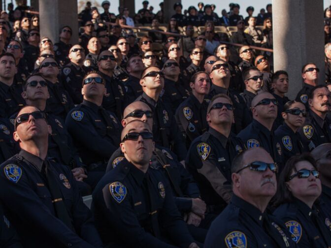 Riverside Police Officers watch a flyover at a memorial for a slain police officer Michael Crain at Riverside National Cemetery on February 13.