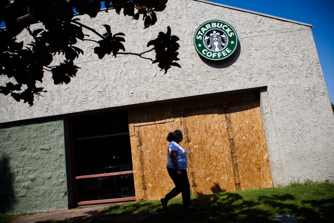 On July 31, 2012, wood still covers damage from recent protests at the Starbucks near Anaheim's City Hall. Members of the community took to the streets after two unrelated police killings of Latino youth on July 21 and 22nd.