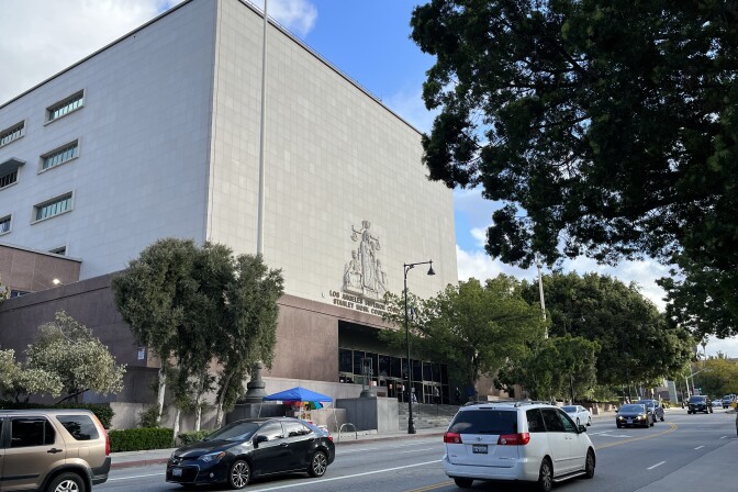 Cars drive past the entrance to the Stanley Mosk Courthouse in Downtown L.A., one of the nation’s busiest trial courts. 