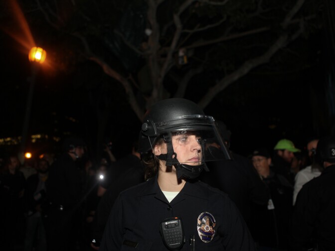 An LAPD officer stands in the center of City Hall park. More than 1,400 personnel took part in the raid.