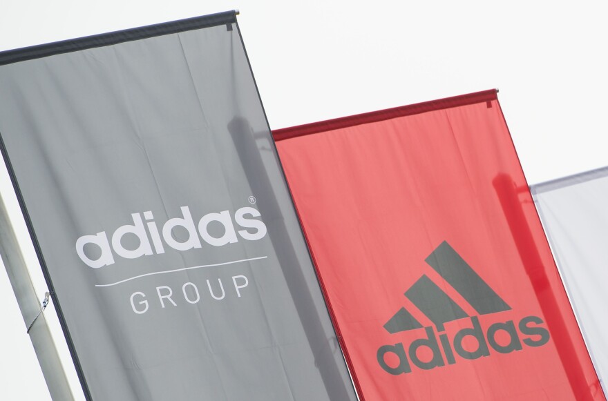 The logo of German sport brand Adidas is pictured on waving flags in front of the Adidas Headquarter in Herzogenaurach on January 25, 2016. / AFP / LUKAS BARTH        (Photo credit should read LUKAS BARTH/AFP/Getty Images)