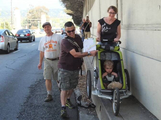 Walkers balance a stroller on the narrow sidewalk of Hyperion Ave. The pedestrian advocacy group L.A. Walks is pressing Los Angeles to install full sidewalks on both sides of Hyperion. A city engineer's recommendation recently adopted by the city Board of Public Works recommends a single 6-foot wide sidewalk on the north side of Hyperion.