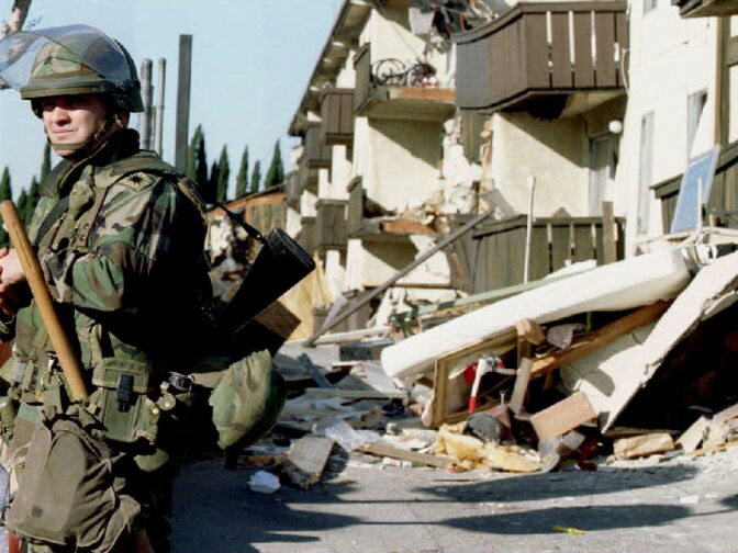 A National Guardsman stands guard outside the ruins of the Northridge Meadows Apartments where 16 people died during the Jan. 17, 1994 earthquake that rocked Southern California.