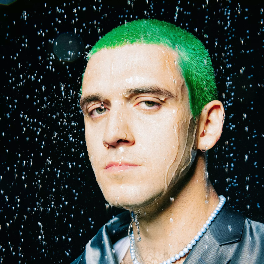 A man with green hair in simulated rain.