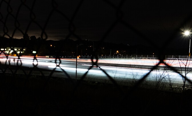 A bright road with a streetlight and an office building.